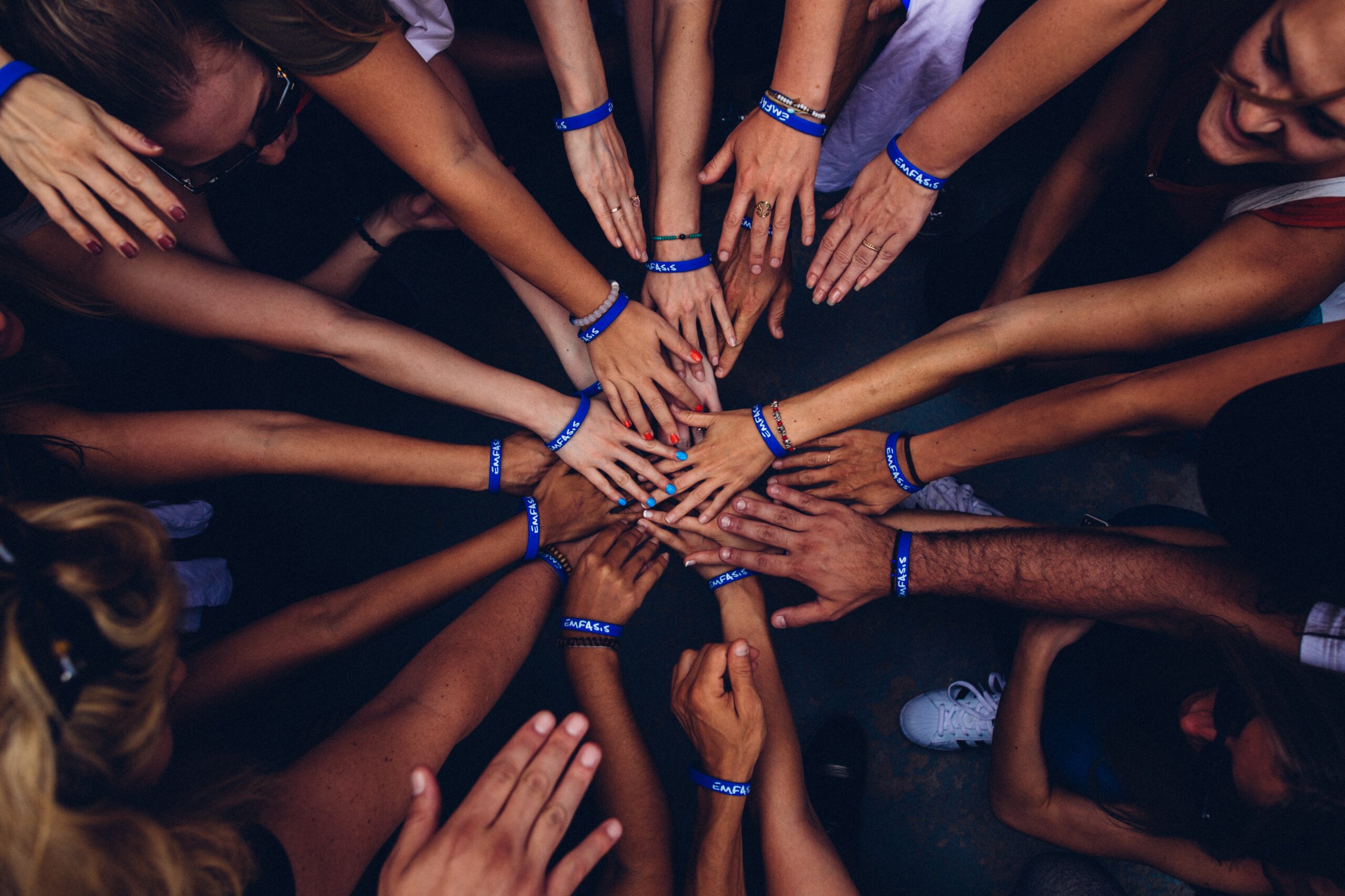 Photo of hands joined in the center of a circle huddle Photo: Perry Grone