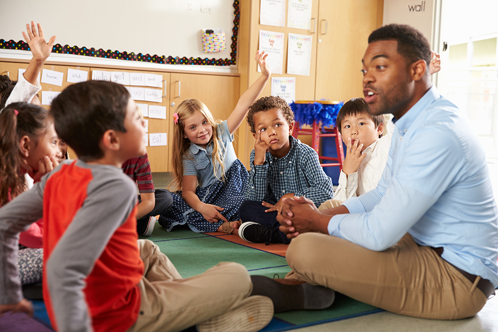 Kids in classroom sitting in circle with teacher