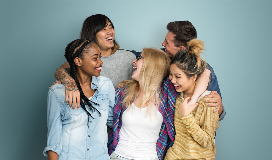 image of 5 young adults huddled together, smiling