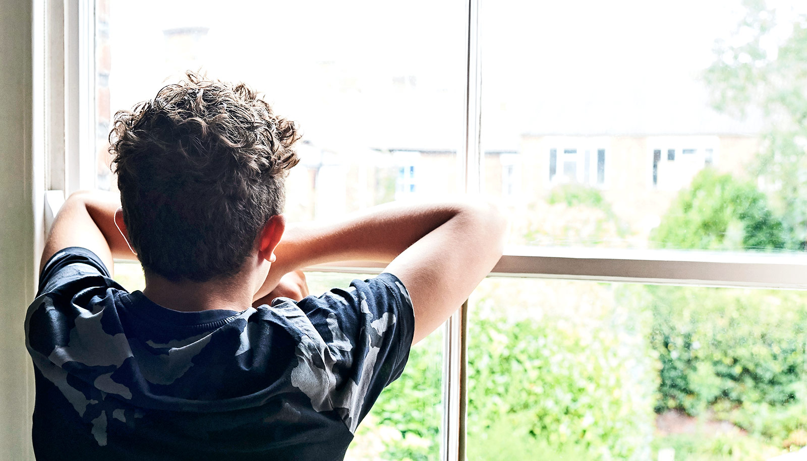Young boy looking out a window