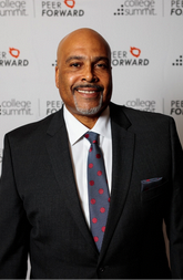 A Black man with a goatee wearing a suit and tie.