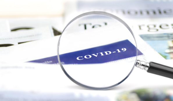 Magnifying glass showing the words "COVID-19"