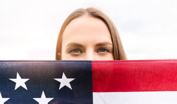 Woman holding a United States flag that covers the lower half of her face