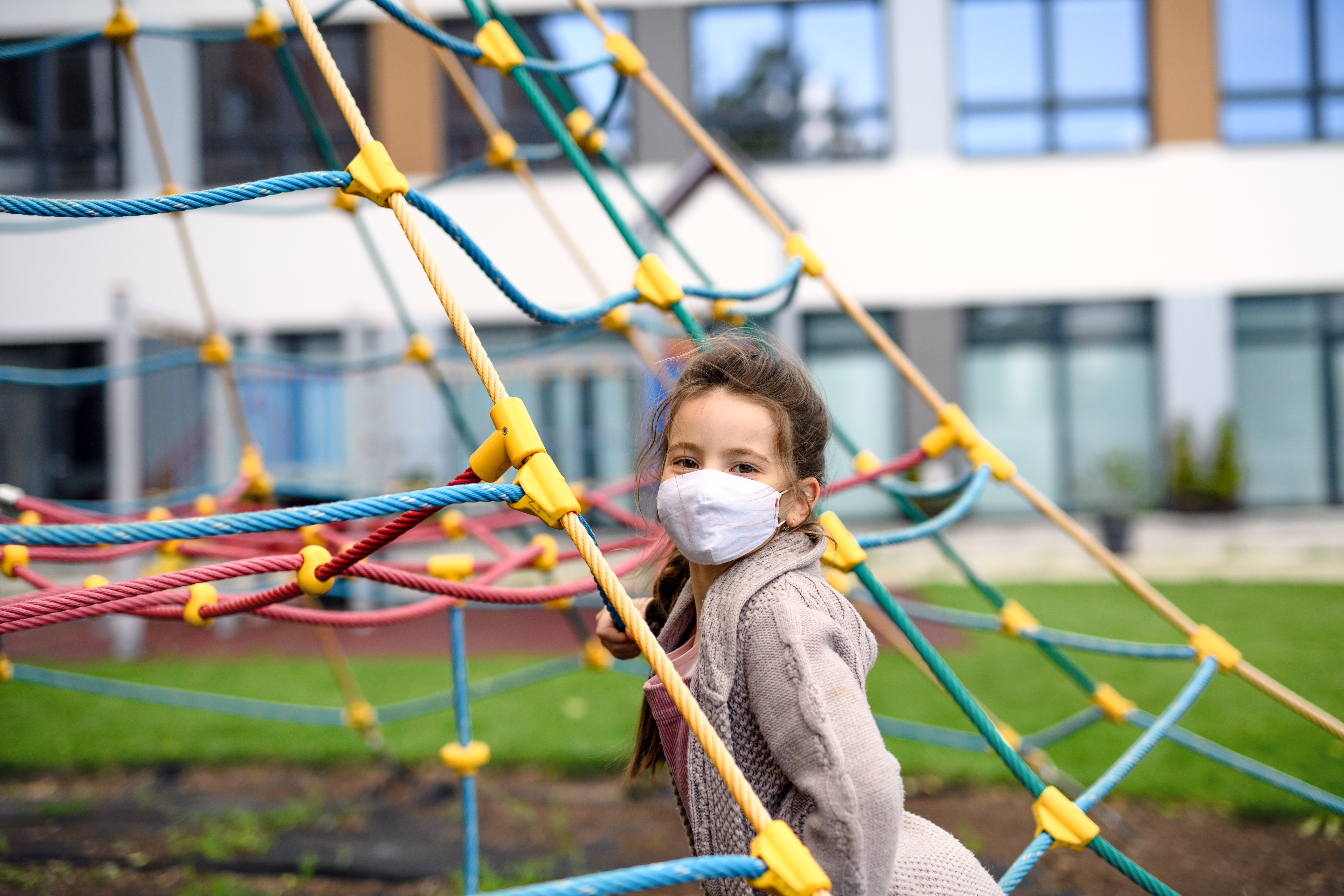 Young girl with mask on playground structure
