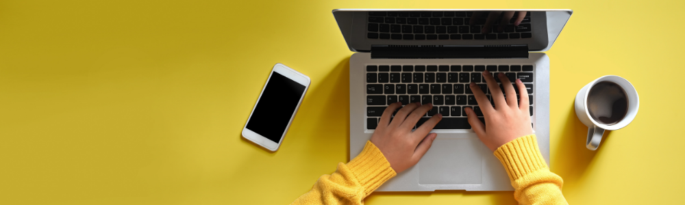 image of hands on a computer with yellow background