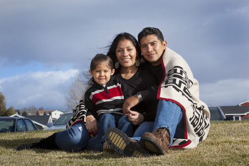 Native family sitting under a blanket