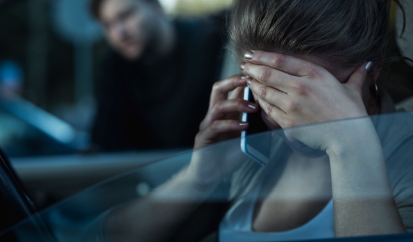 A woman looking distressed on the phone.